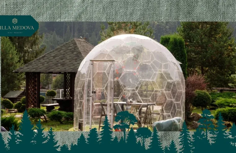 Hlempinh u Karpatakh vidpochynok u prozorykh heokupolakh pid zoryamy Geodesic glass dome and wooden gazebo in a landscaped garden with Villa Medova logo in the corner.